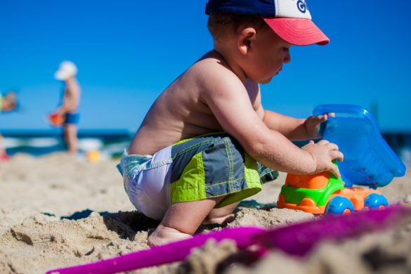 enfant qui joue dans le sable avec jouets