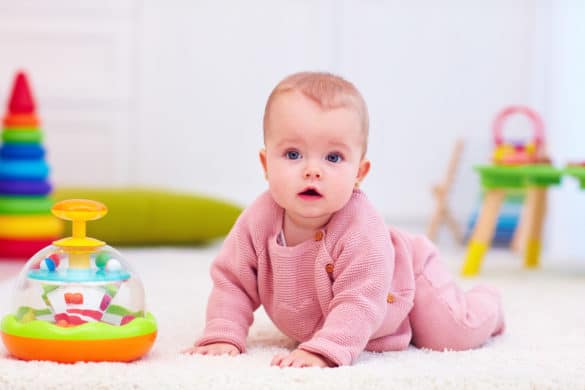 Petite fille bébé joue avec une toupie d'eveil