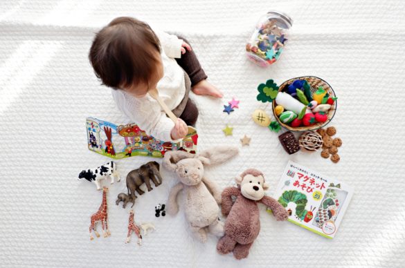 enfant assis avec des jouets autour de lui