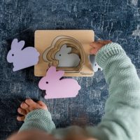 jeune enfant joue avec un puzzle en bois