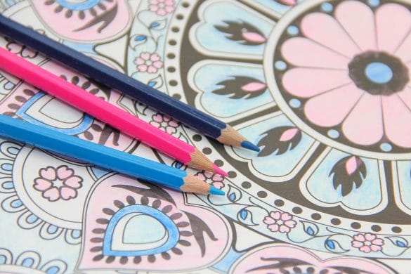 crayons de couleurs posés sur un dessin de mandala