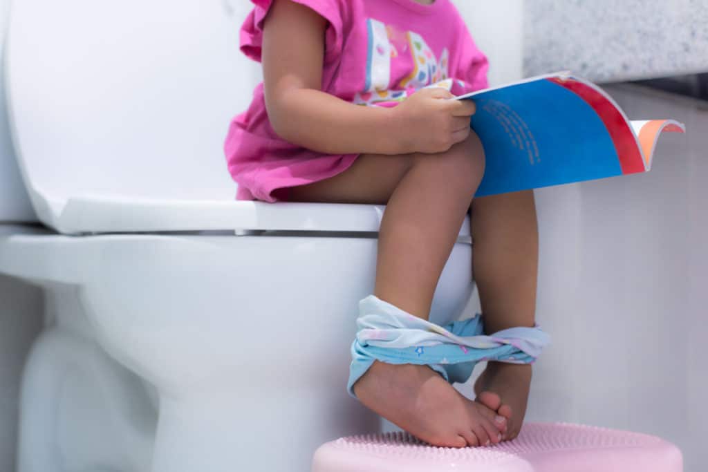 petite fille assise sur les toillettes