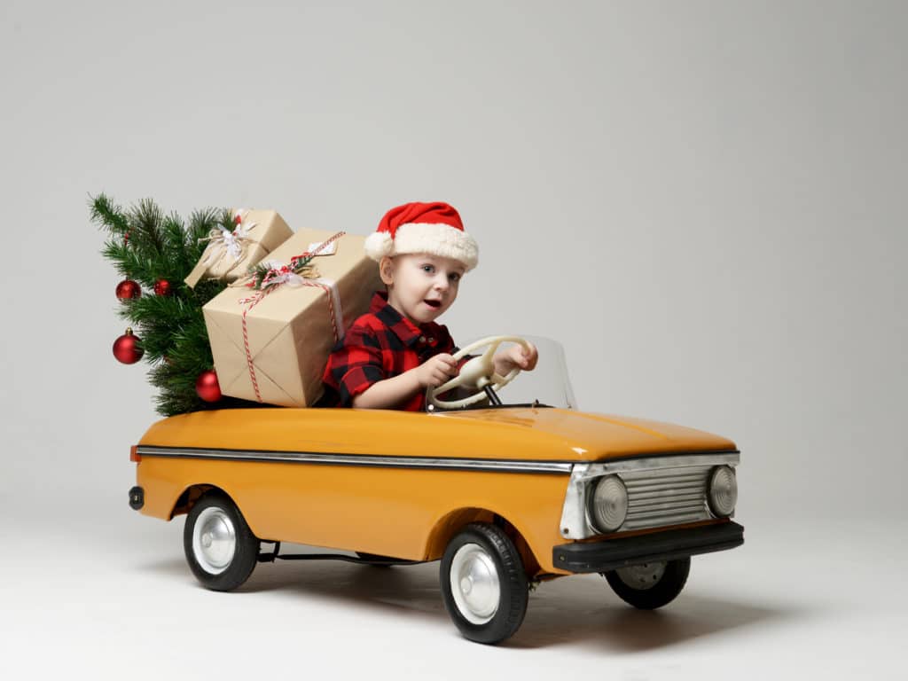 enfant conduit une petite voiture avec cadeaux noel