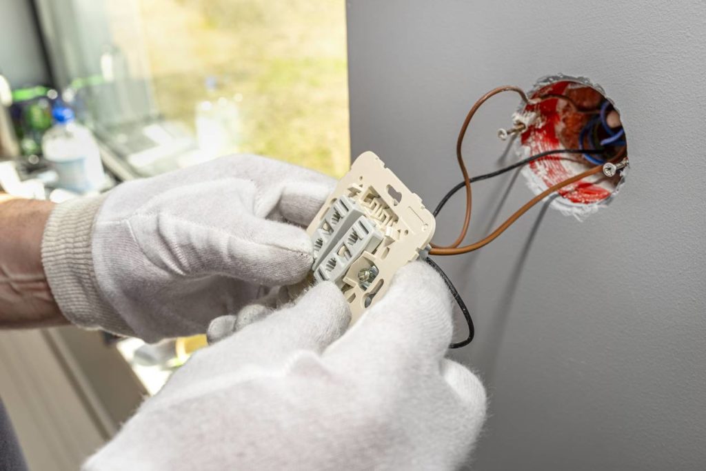 electricien fait un branchement electrique pour volets