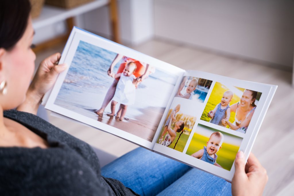 une femme regarde un album photo personnalisé