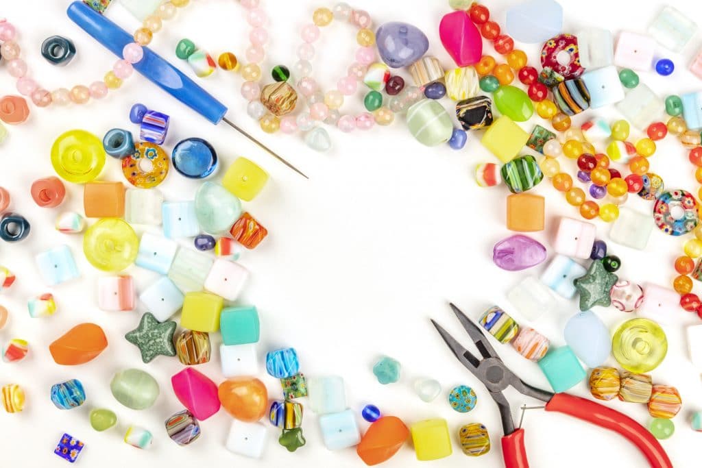 perles de couleurs posées sur une table blanche