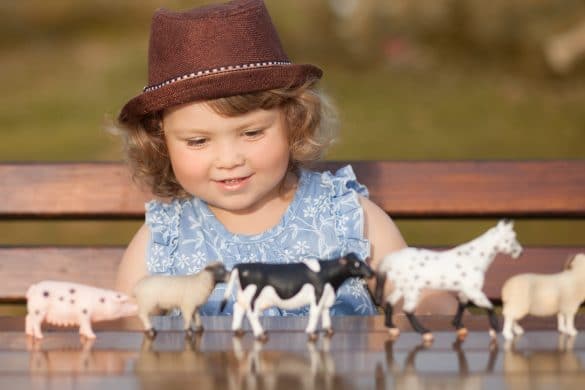 petite fille joue avec des animaux en plastique