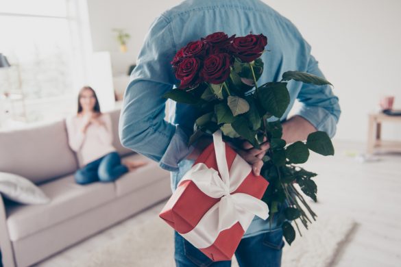 hoimme cache un cadeau et un bouquet de fleurs dans son dos