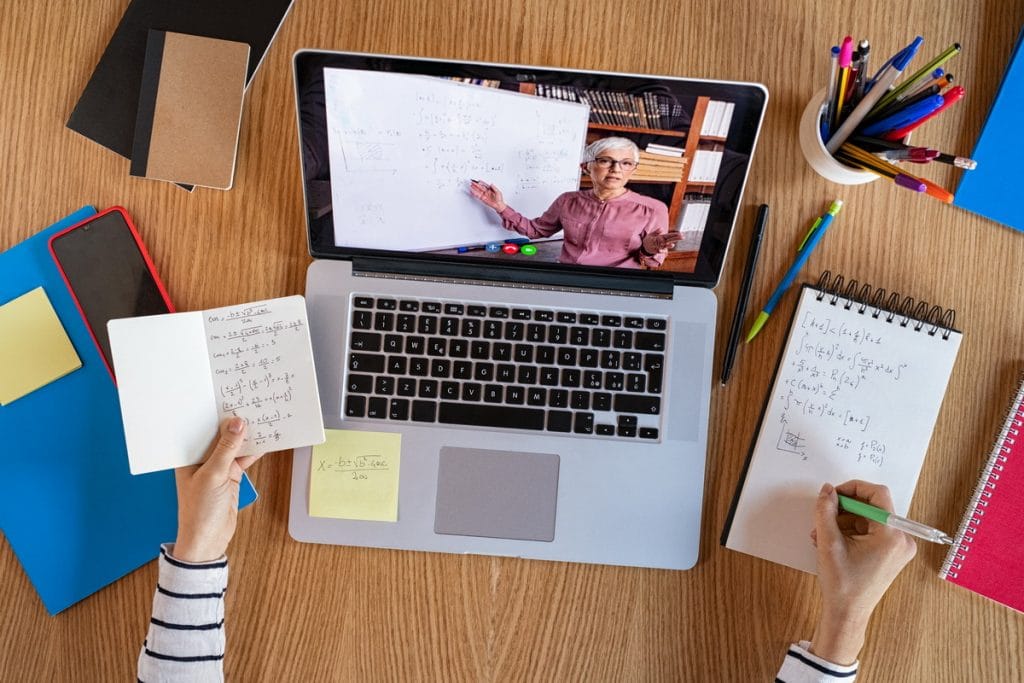 enfant prend des notes et suit un cours de math en ligne