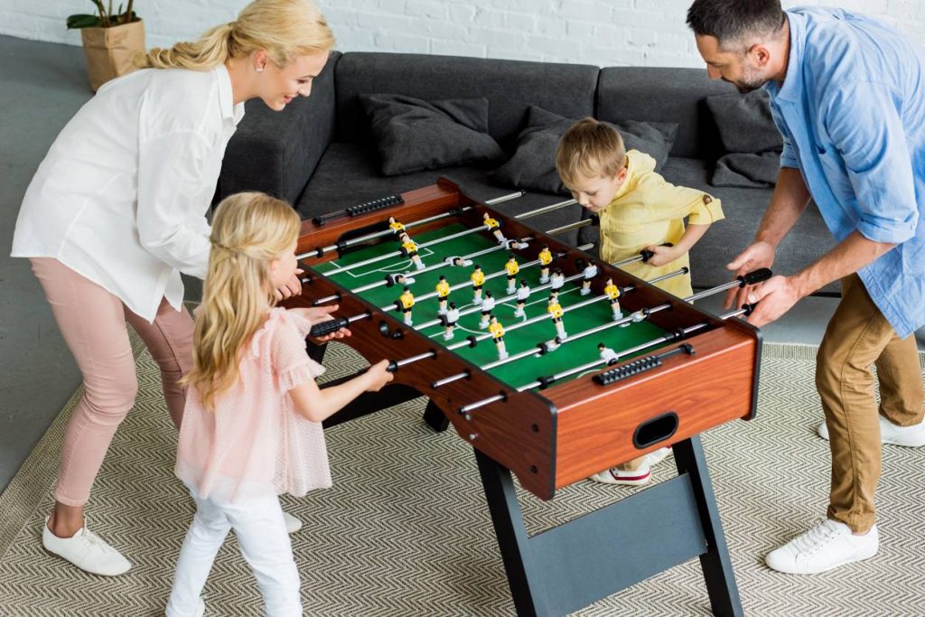 parents et enfant joue au baby foot