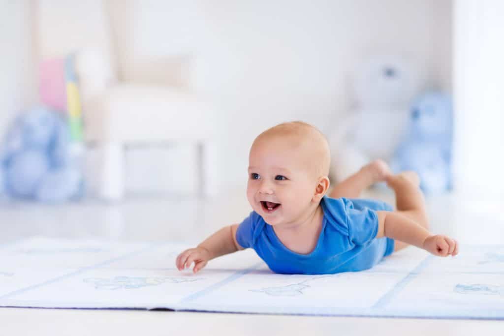 bébé allongé sur le ventre sur un tapis
