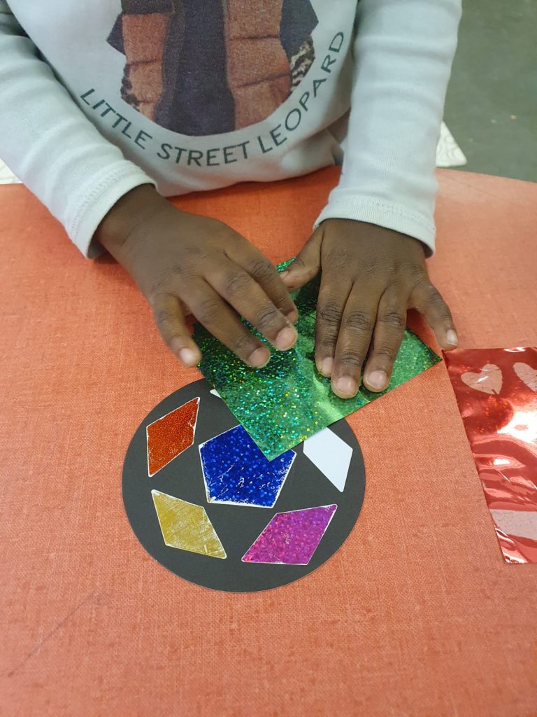 enfant en maternelle applique feuille métalissé sur boule carton