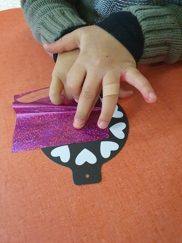 enfant appuie sur feuille métallisé
