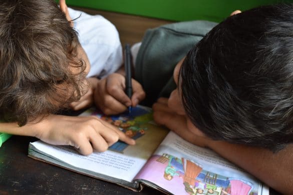 2 enfants lisent un livre ensemble