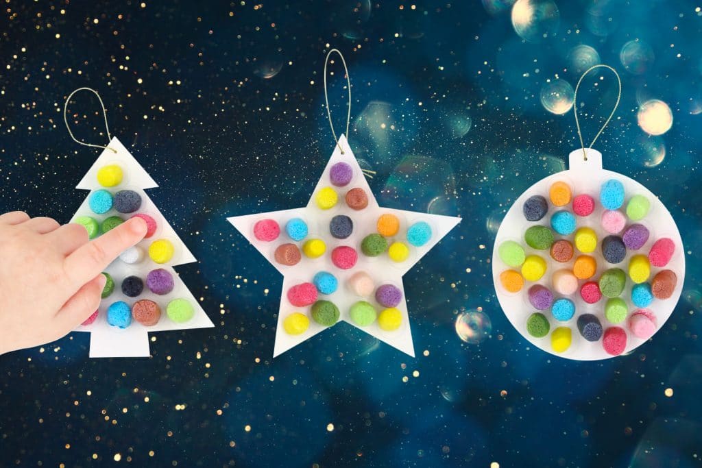 enfant touche du doigt une décoration de noel