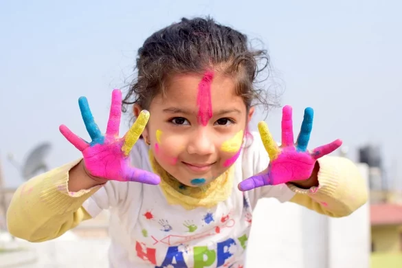 petite fille montre ses mains peintes en couleurs