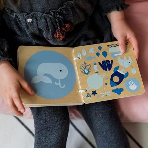 enfant lit un livre posé sur ses genoux