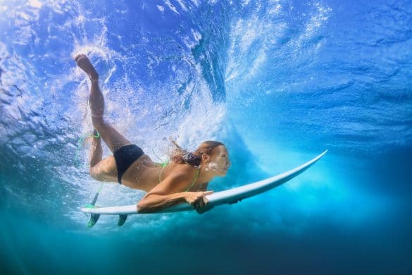 jeune femme sous l'eau en mer sur une planche