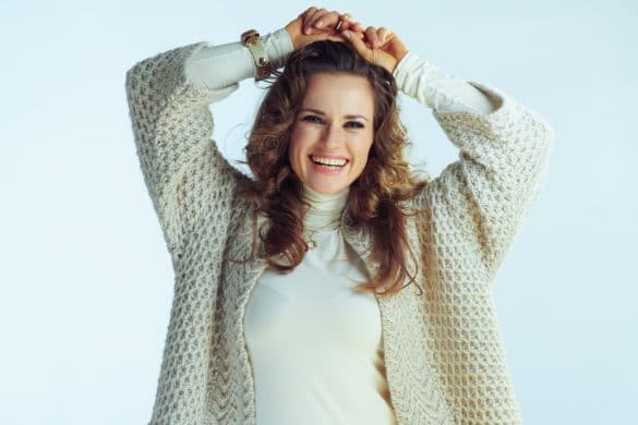 jeune femme brune aux cheveux longs porte un gilet beige