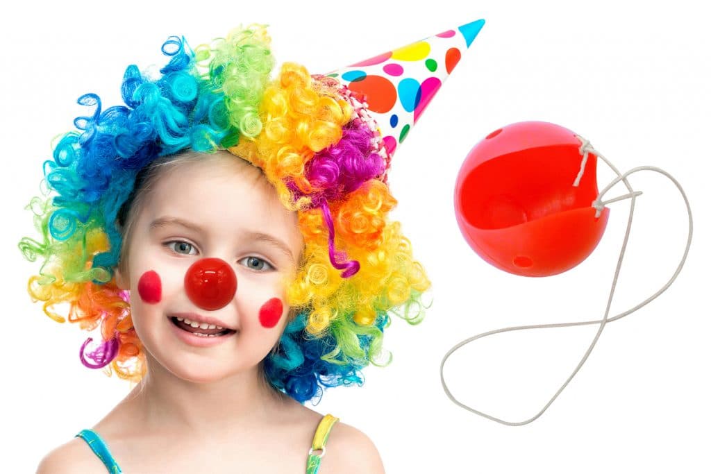 petite fille porte un nez rouge de clown