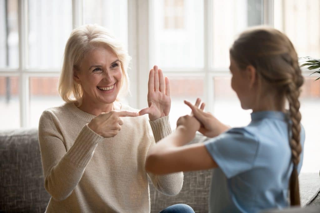 femme communique avec une petit fille par les signes