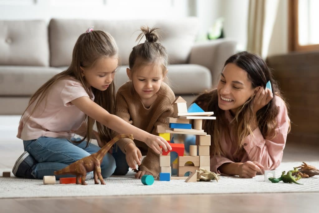 garde enfant jeune femme joue avec 2 petites filles