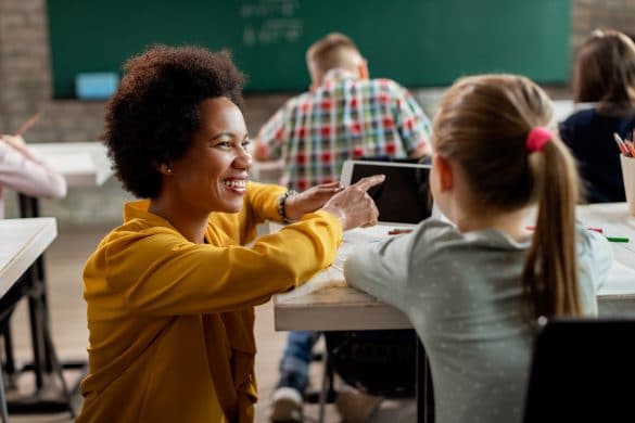 Une maîtresse souriante parle avec une petite fille