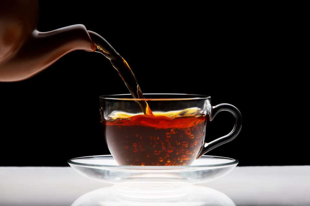 théière verse du thé chaud dans une tasse
