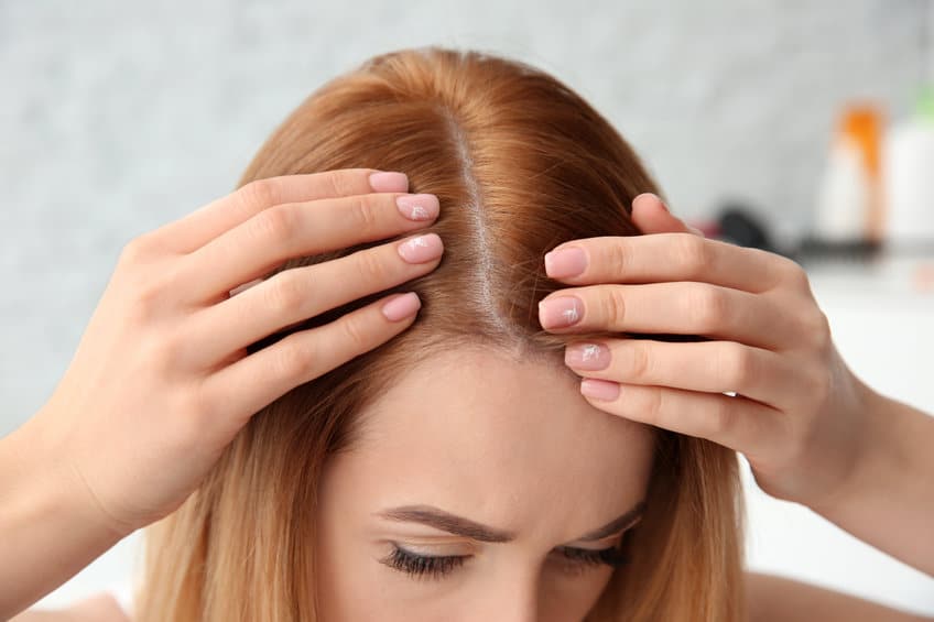 jeune femme pose mains sur ses cheveux
