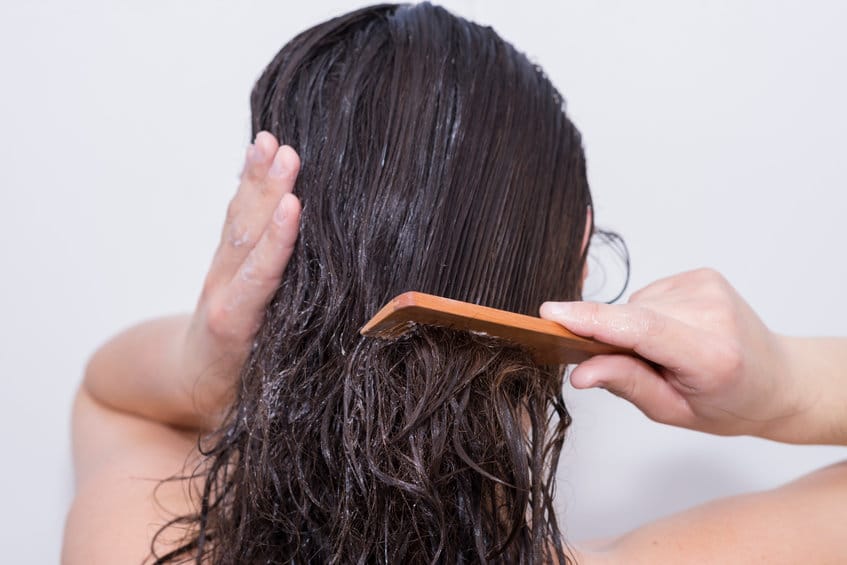 jeune femme démêle des cheveux longs