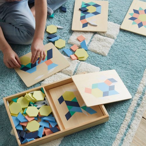 enfant joue avec un jeu de trangram en bois