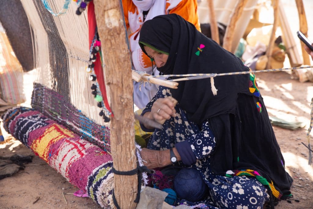 femme marocaine tisse un tapis berbère traditionnel