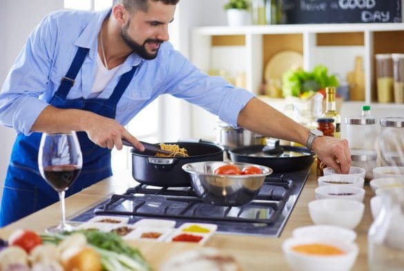 homme prépare des plats dans sa cuisine