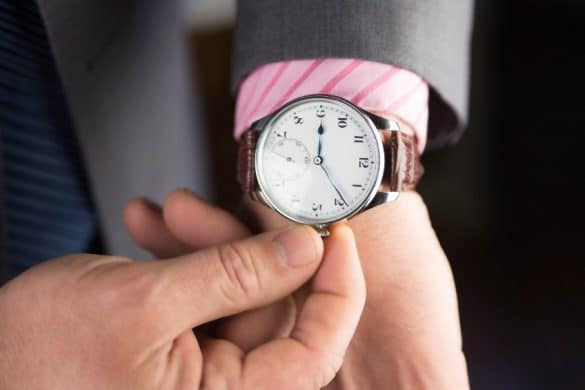 Homme remonte les aiguilles de sa montre