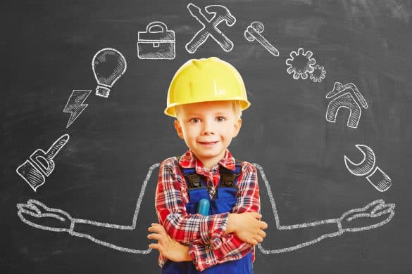 Enfant bricoleur avec un casque devant un tableau noir avec pictogramme bricolage