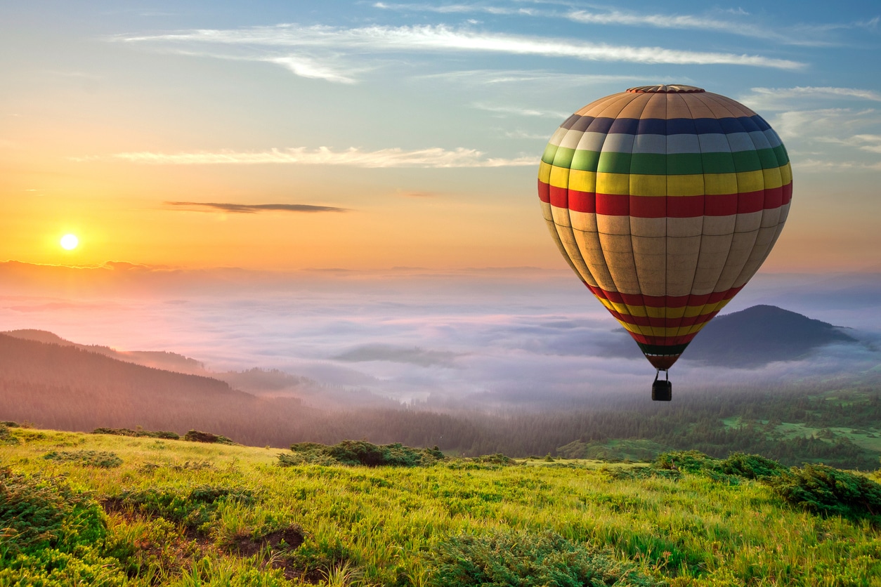 Montgolfière dans le ciel avec paysage et nuages