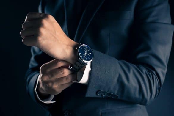 homme habillé en costume porte une montre au poignet