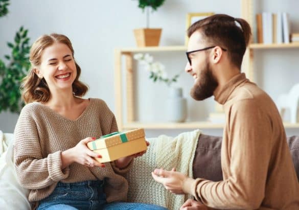 Jeune homme offre un cadeau avec un ruban à une jeune femme