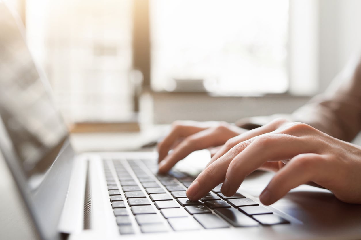 personne fait une saisie sur un clavier d'ordinateur portable