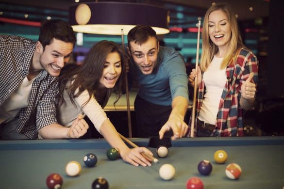 4 personnes jouent ensemble au billard
