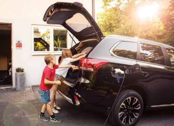 enfants chargent des bagages dans un coffre pour partir en vacances