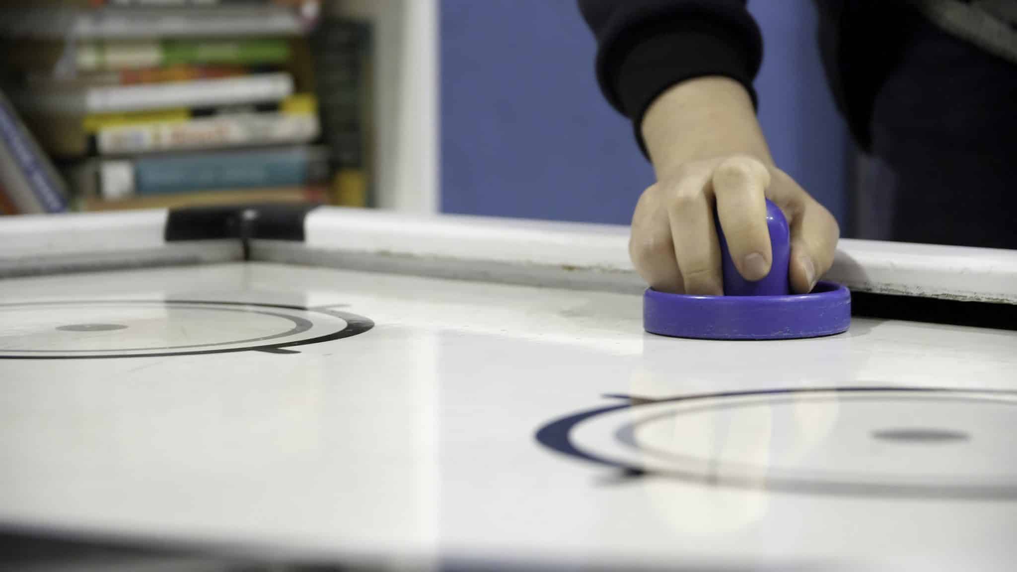 homme joue avec un jeu de galet sur une table de jeux