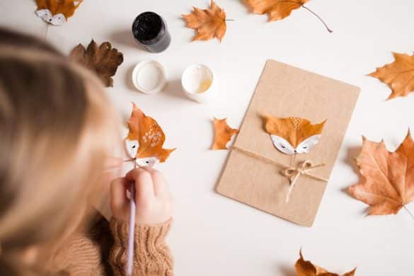 enfant peint un renard sur une feuille d'automne
