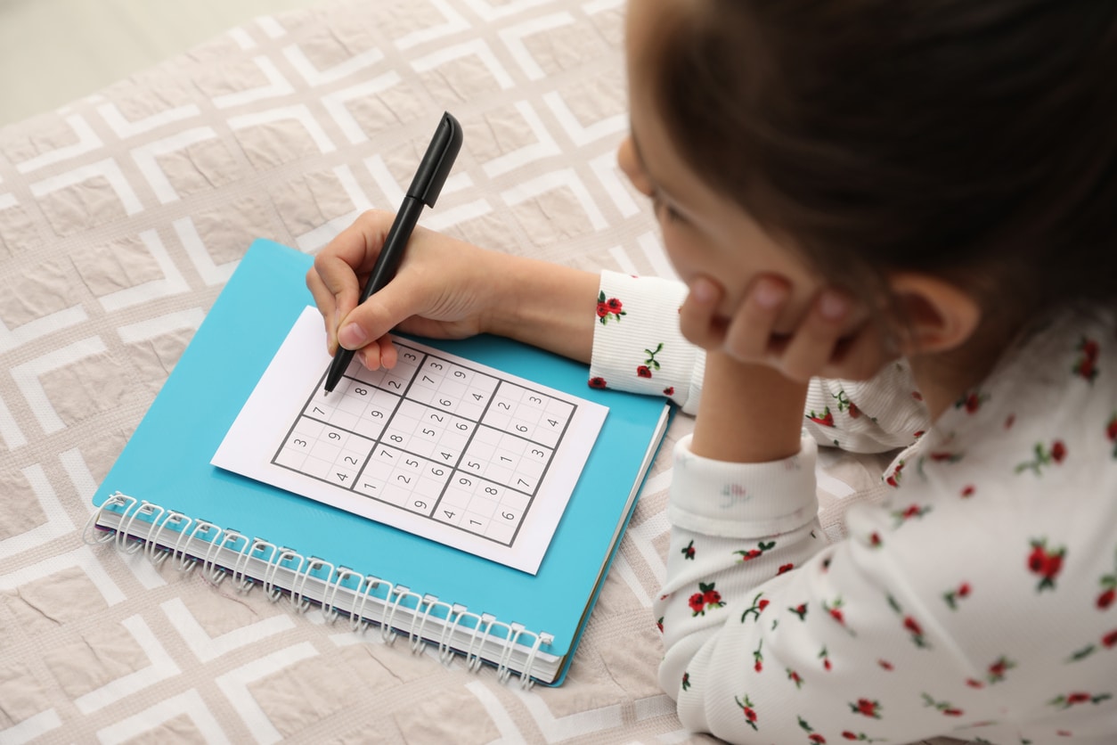 petite fille joue seule au sudoku