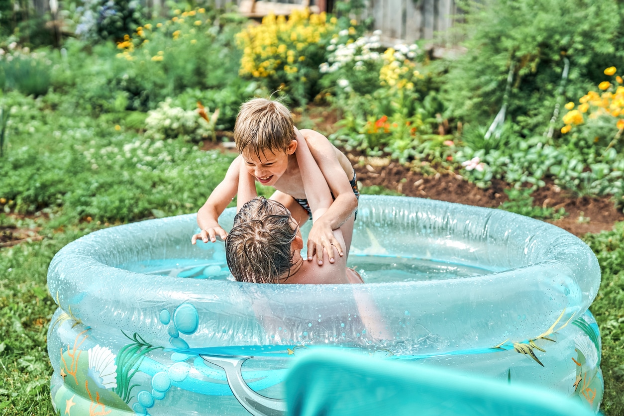deux enfants jouent dans une piscine gonflable