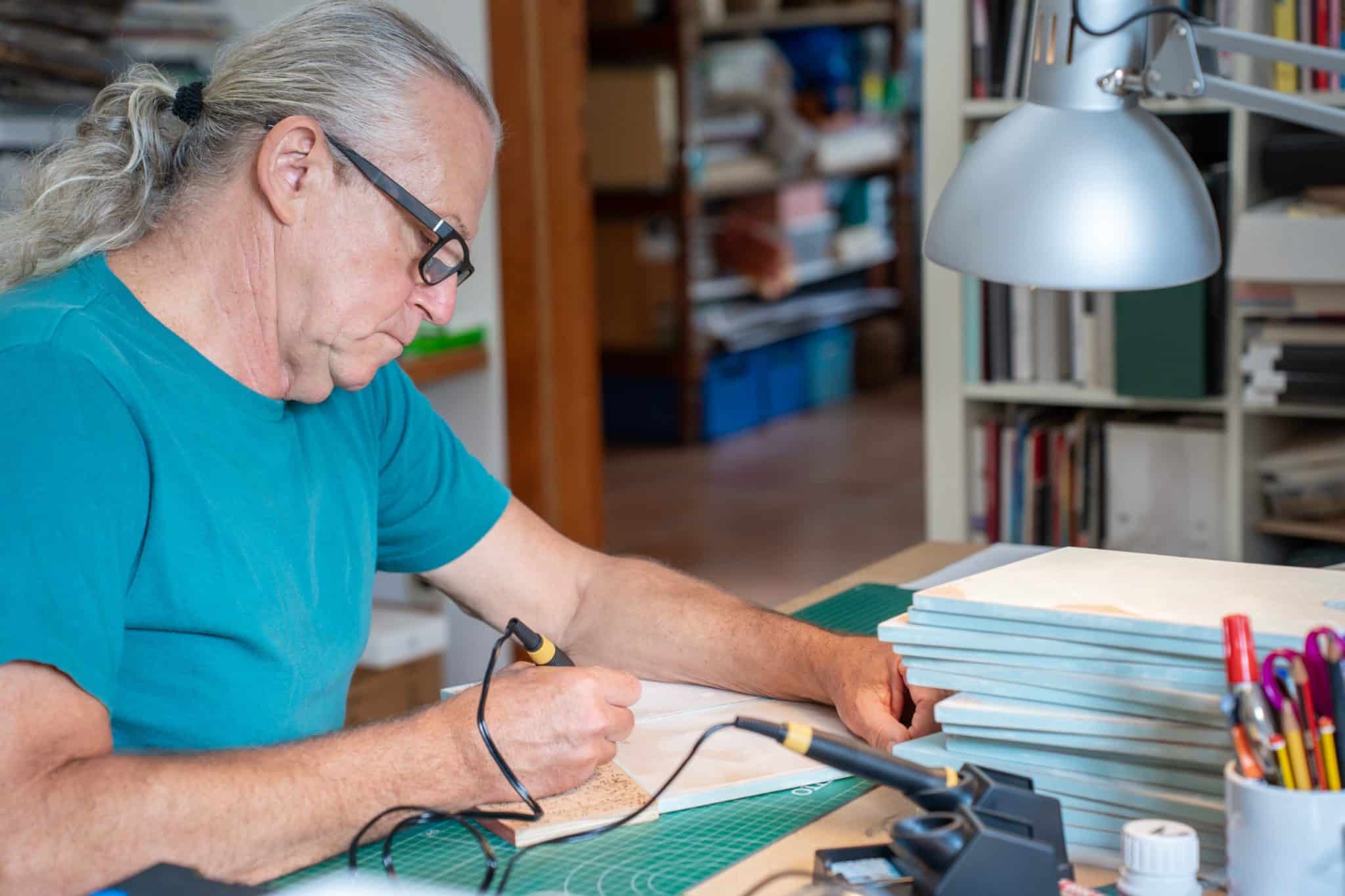 homme avec un tee-shirt bleu utilise un pyrograveur