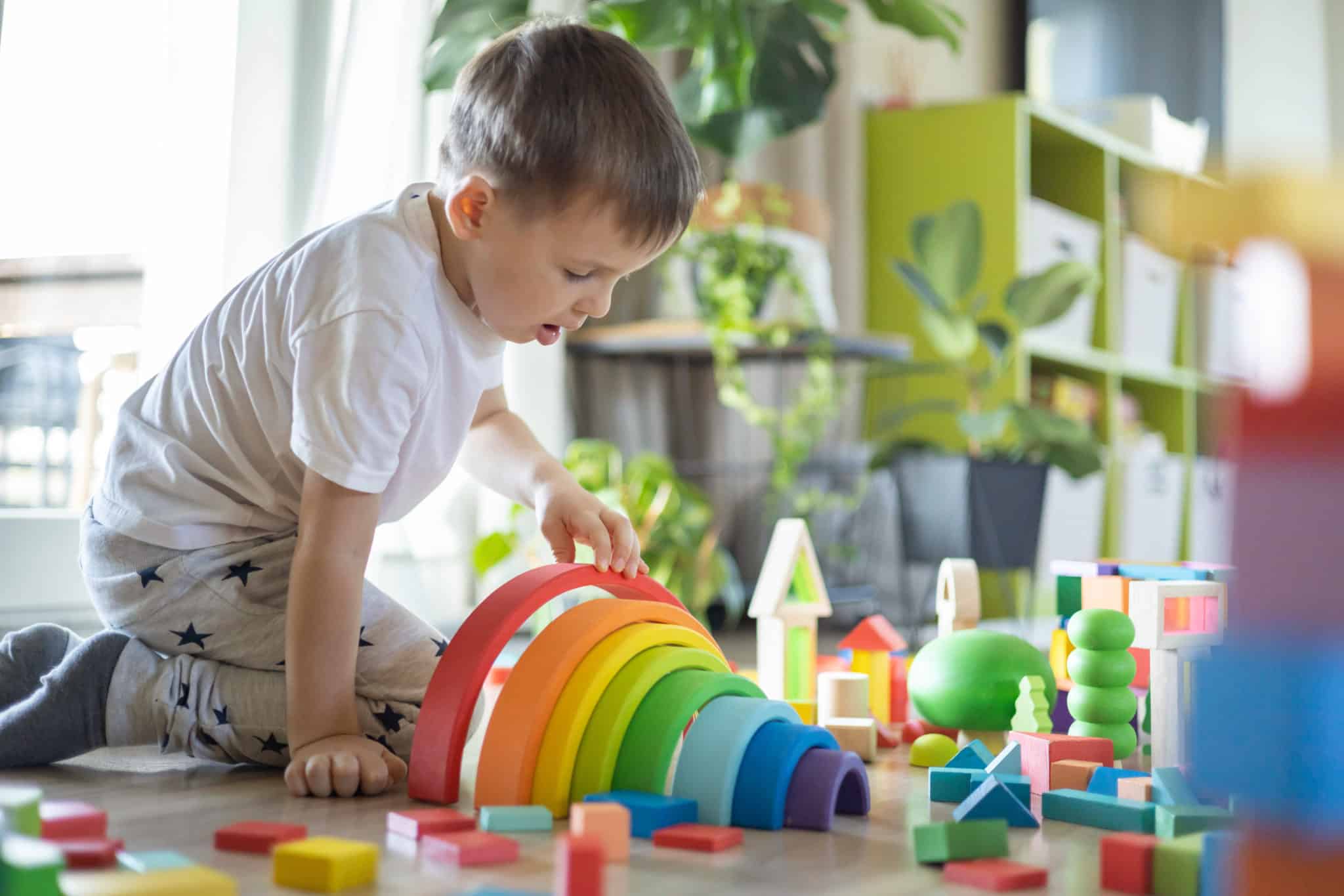 petit garçon joue avec des jouets en bois