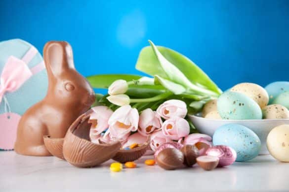 lapins de pâques en chocolat posé à côté d'un bouquet de fleurs tulipes coloris pastel
