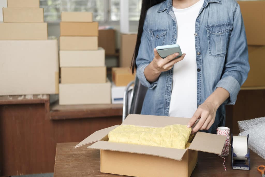 femme enregistre le rangement d'un carton
