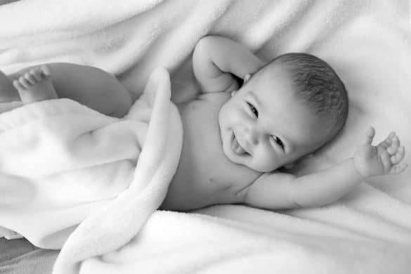 bébé allongé sur une couverture blanche